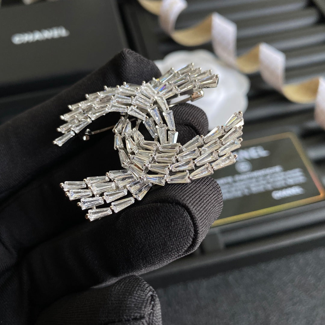 Broche con el logotipo de cristal brillante