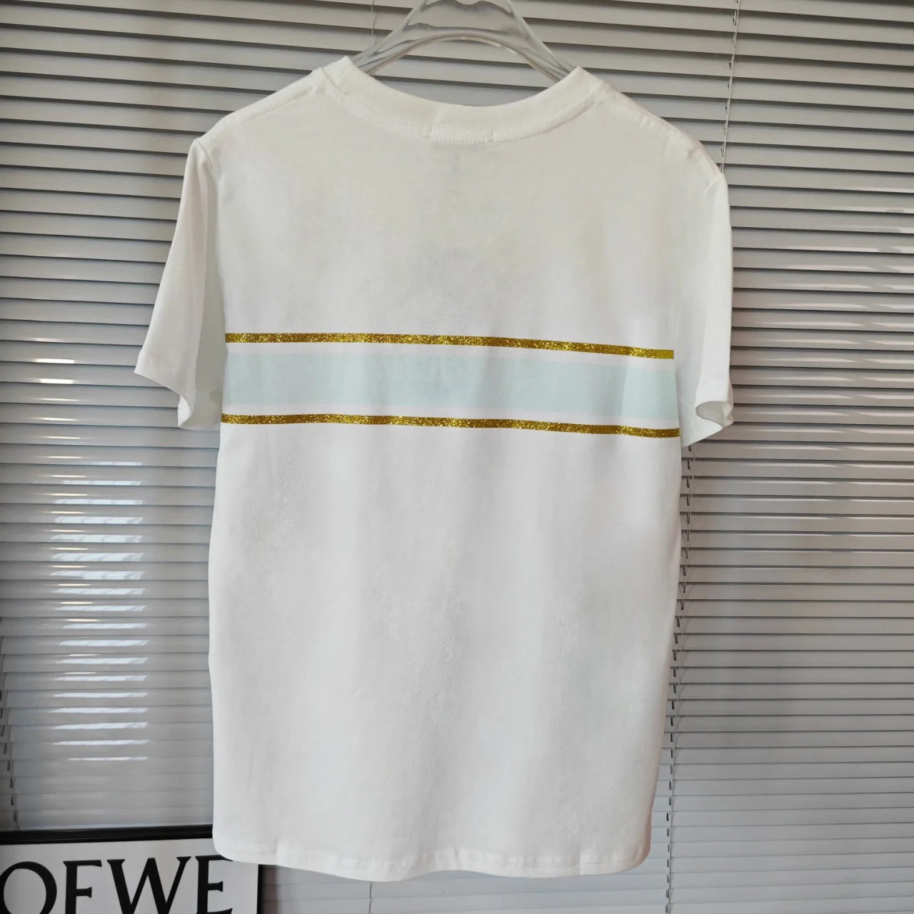 Camiseta con mariposa bordada y logo en tono dorado