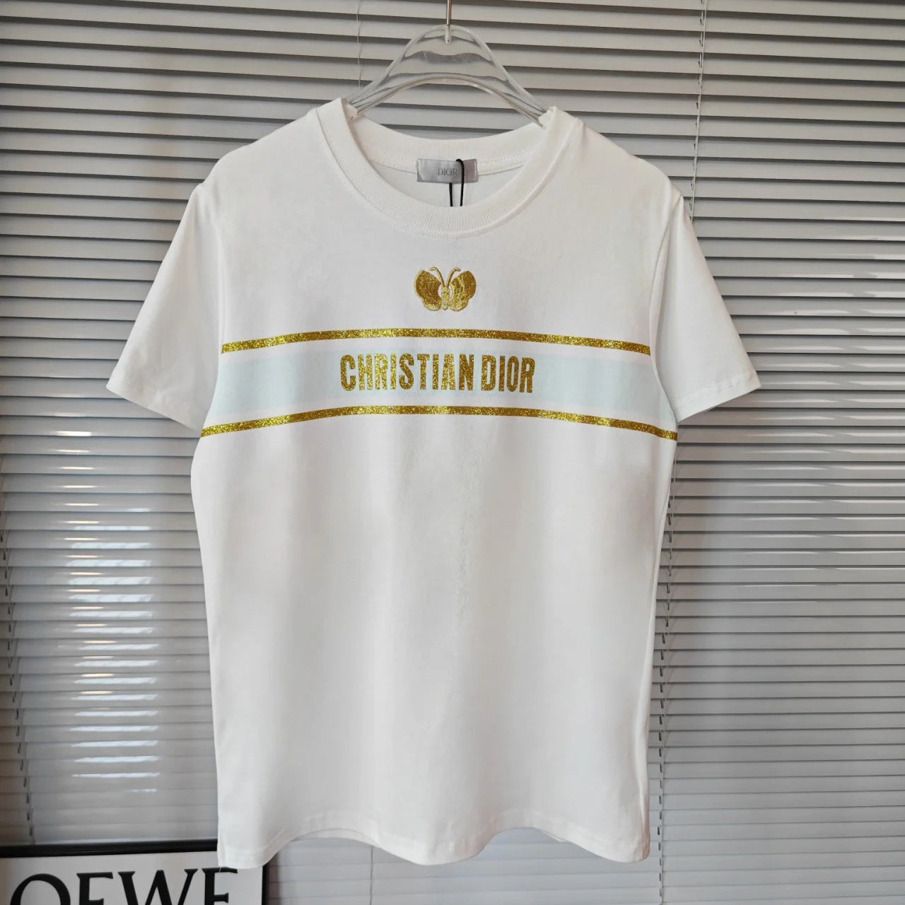 Camiseta con mariposa bordada y logo en tono dorado