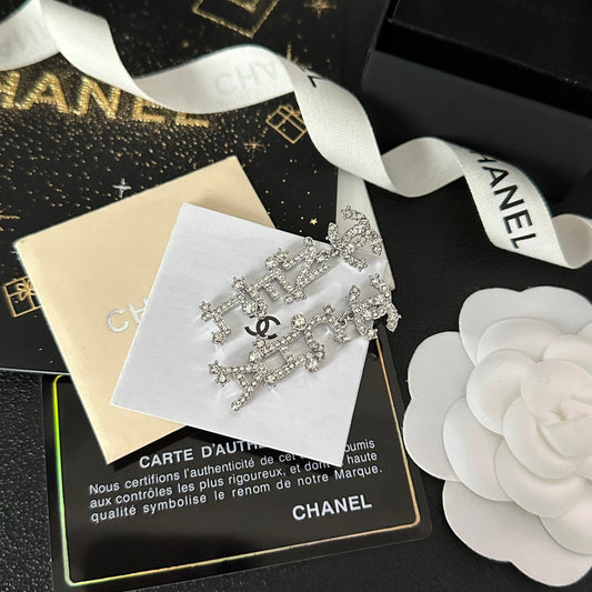 Boucles d'oreilles pendantes signature diamantées en forme de lettre