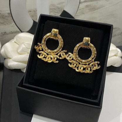 Boucles d'oreilles créoles dorées avec pendentif pompon