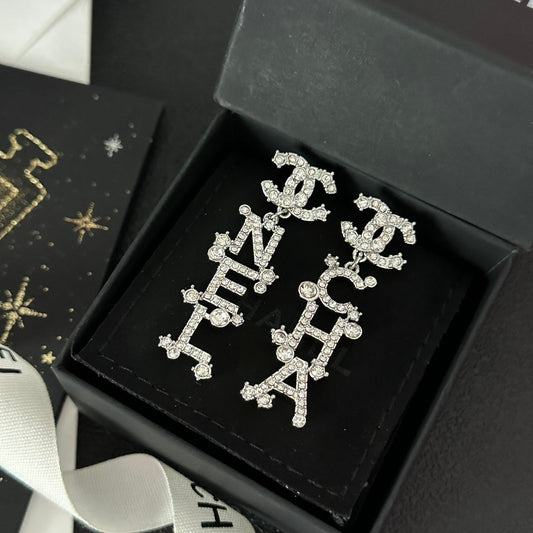 Boucles d'oreilles pendantes signature diamantées en forme de lettre