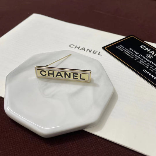 Broche con tira de logo y letras