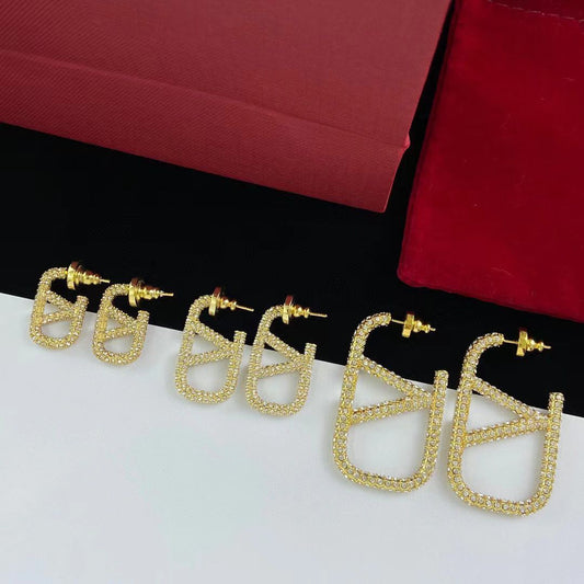 Boucles d'oreilles logo en métal entièrement pavé de diamants