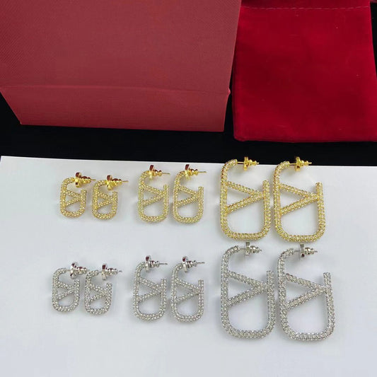 Boucles d'oreilles logo en métal entièrement pavé de diamants