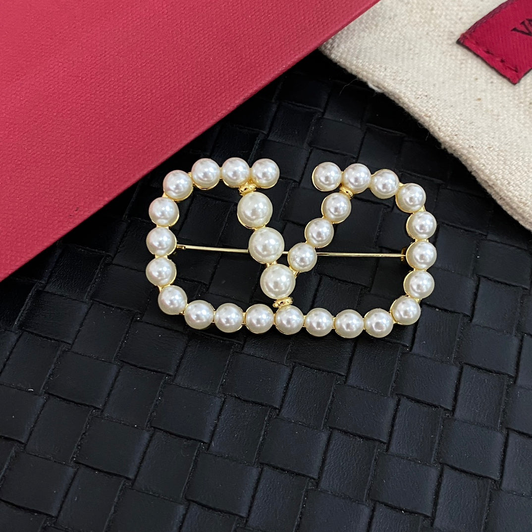 Elegante broche en V con perlas
