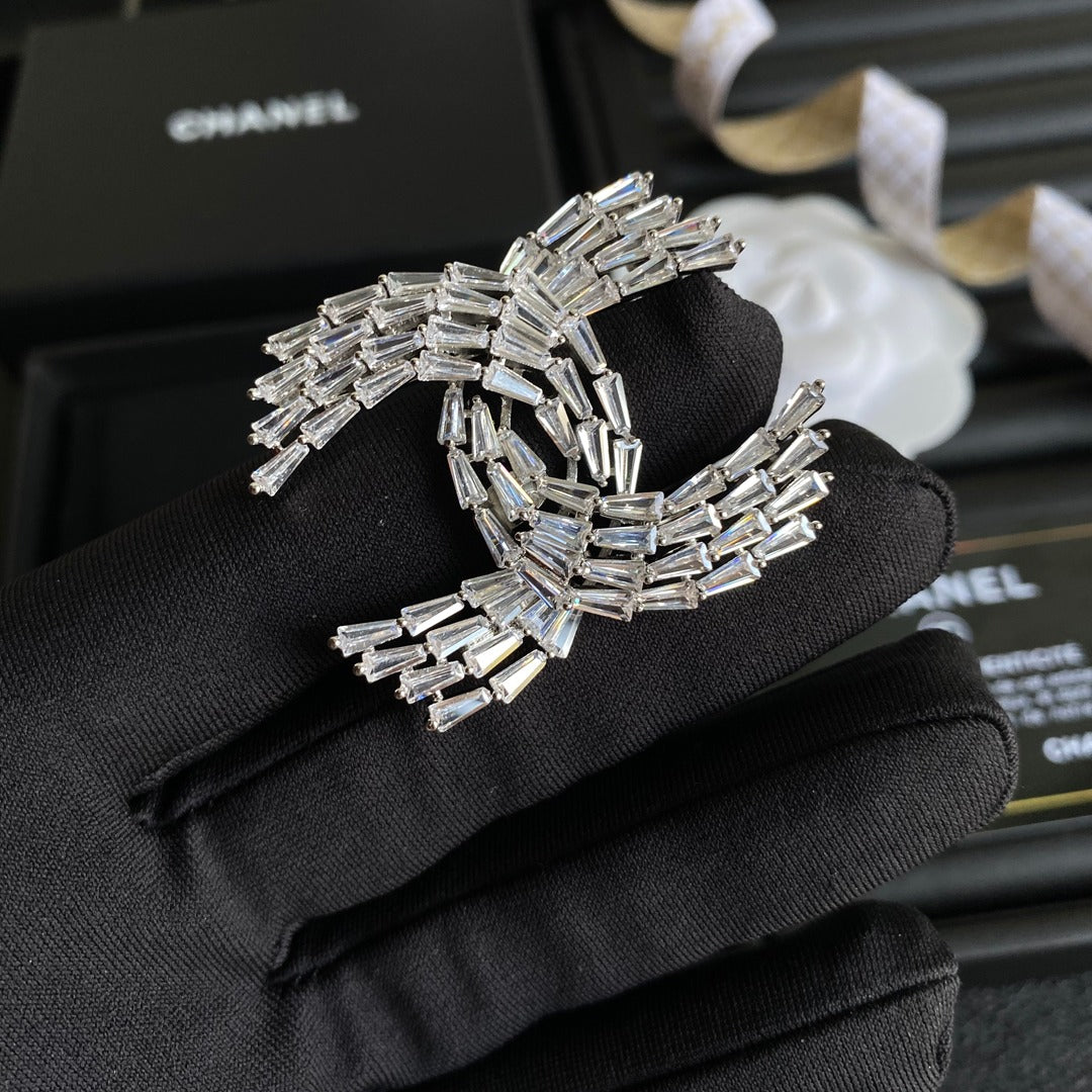 Broche con el logotipo de cristal brillante