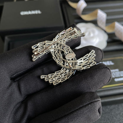 Broche con el logotipo de cristal brillante