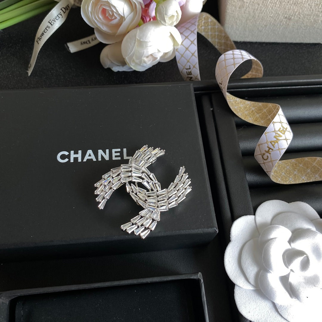 Broche con el logotipo de cristal brillante